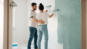 Mężczyzna i kobieta malują ścianę w mieszkaniu